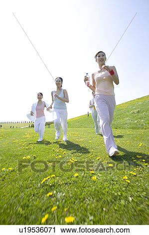 Four young women running in field View Large Photo Image Stock Image - Four young women running in field. Fotosearch
