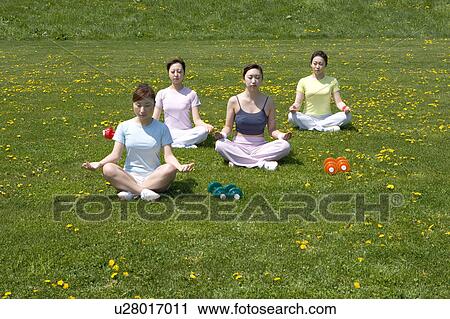 Four young women sitting in lotus position View Large Photo Image Stock Image - Four young women sitting in lotus position. Fotosearch