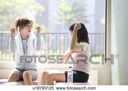 Stock Photography - Two young women chatting in gym. Fotosearch