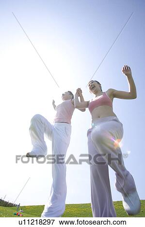 Stock Photo - Two young women skipping in field. Fotosearch