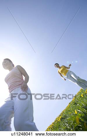 Two young women walking in field View Large Photo Image Stock Image - Two young women walking in field. Fotosearch