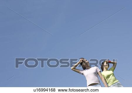 Stock Photo - Two young women wiping their foreheads. Fotosearch