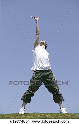 Young man exercising in field View Large Photo Image Picture - Young man exercising in field. Fotosearch