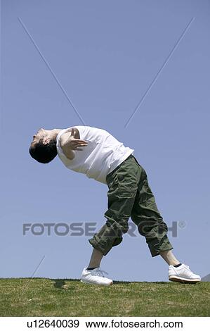 Young man exercising in field View Large Photo Image Stock Photo - Young man exercising in field. Fotosearch