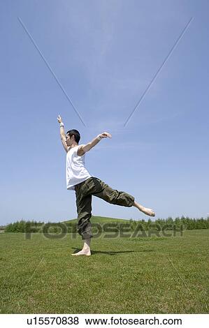 Stock Photo - Young man exercising in field. Fotosearch