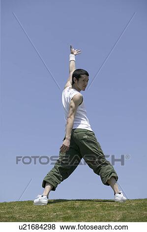 Young man exercising in field View Large Photo Image Stock Photo - Young man exercising in field. Fotosearch