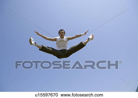 Young man jumping and doing splits in mid air View Large Photo Image Stock Image - Young man jumping and doing splits in mid air. Fotosearch