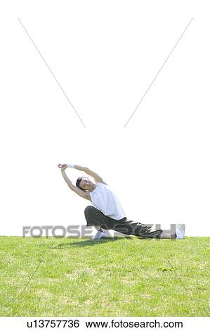 Young man stretching in field View Large Photo Image Stock Photograph - Young man stretching in field. Fotosearch