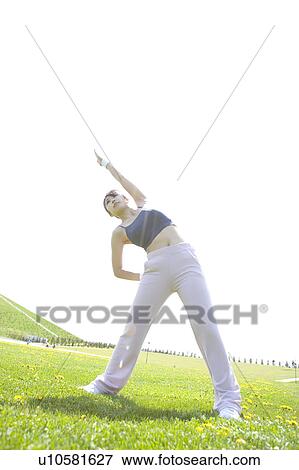 Young woman exercising in field View Large Photo Image Stock Photo - Young woman exercising in field. Fotosearch