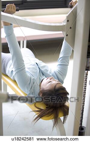Young woman exercising in gym View Large Photo Image Stock Image - Young woman exercising in gym. Fotosearch