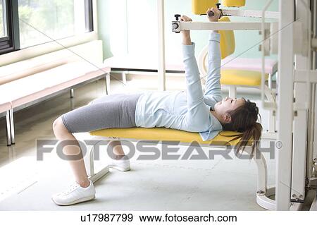 Young woman exercising in gym View Large Photo Image Stock Photo - Young woman exercising in gym. Fotosearch