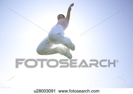 Young woman jumping View Large Photo Image Stock Image - Young woman jumping. Fotosearch