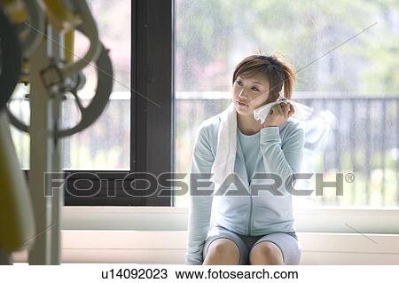 Young woman sitting and wiping her face View Large Photo Image Stock Image - Young woman sitting and wiping her face. Fotosearch