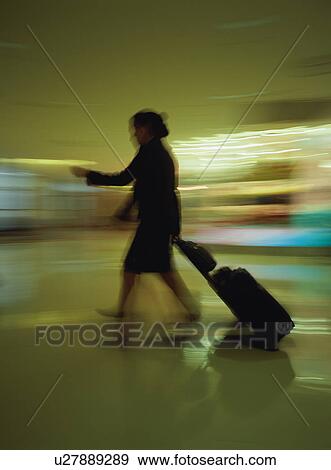 Cabin crew walking with luggage at airport, blurred motion View Large Photo Image Stock Photo - Cabin crew walking with luggage at airport, blurred motion. Fotosearch