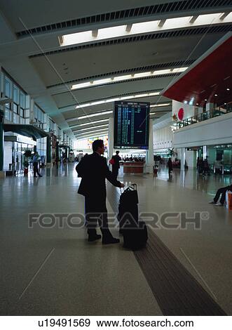 Stock Photo - Man standing at airport terminal. Fotosearch