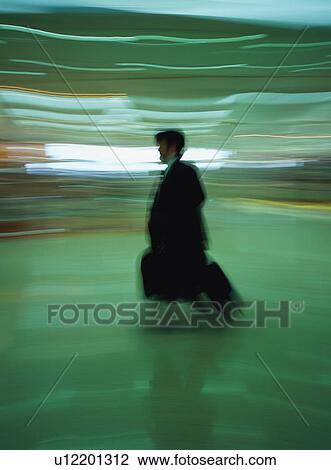 Man walking with luggage at airport, blurred motion View Large Photo Image Stock Image - Man walking with luggage at airport, blurred motion. Fotosearch