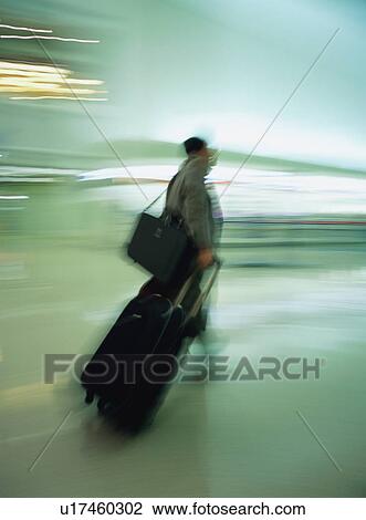 Man walking with luggage at airport, blurred motion View Large Photo Image Stock Image - Man walking with luggage at airport, blurred motion. Fotosearch
