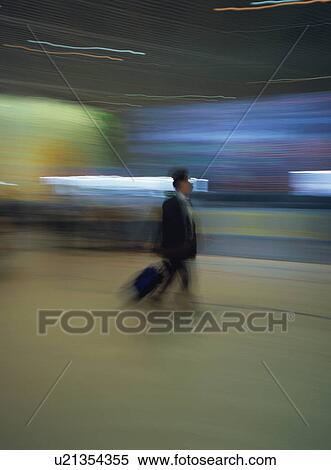 Man walking with luggage at airport, blurred motion View Large Photo Image Stock Photography - Man walking with luggage at airport, blurred motion. Fotosearch