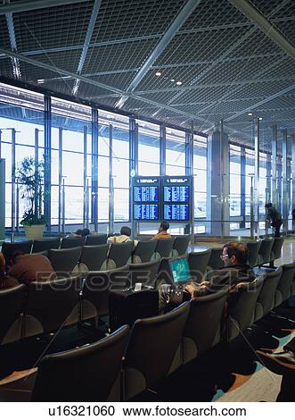 Travelers sitting at airport terminal View Large Photo Image Stock Image - Travelers sitting at airport terminal. Fotosearch