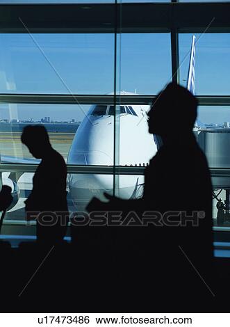 Stock Photograph - Travelers waiting to board airplane. Fotosearch