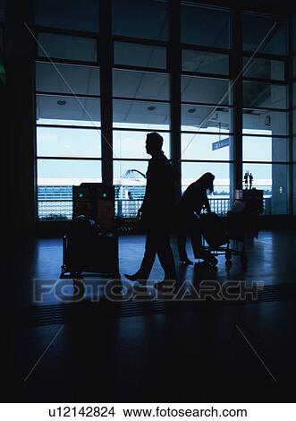 Picture - Travelers walking through airport terminal. Fotosearch