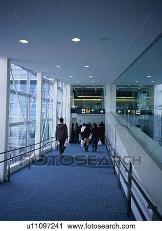 Travelers walking through airport terminal View Large Photo Image Stock Image - Travelers walking through airport terminal. Fotosearch