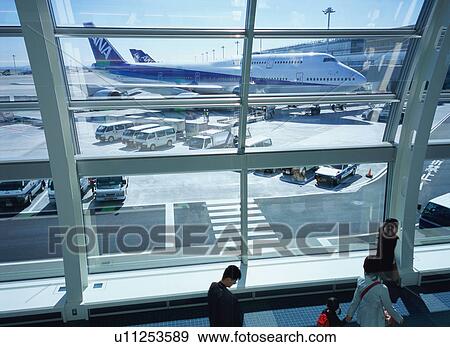 Travelers walking through airport terminal View Large Photo Image Stock Photo - Travelers walking through airport terminal. Fotosearch