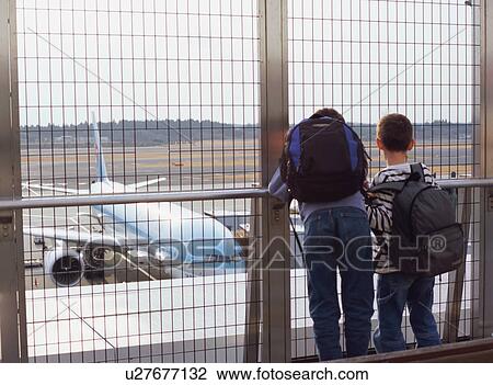 Two children looking at airplane View Large Photo Image Stock Image - Two children looking at airplane. Fotosearch