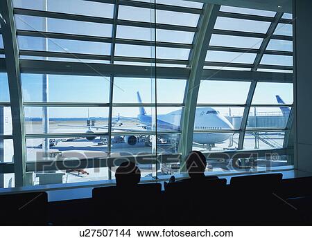 Two travelers waiting to board airplane View Large Photo Image Picture - Two travelers waiting to board airplane. Fotosearch