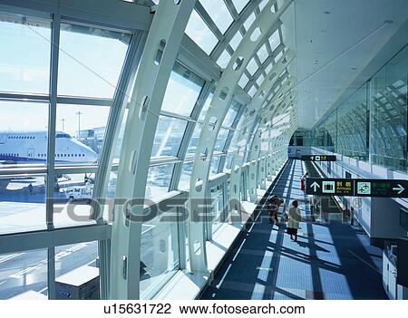Two travelers walking through airport terminal View Large Photo Image Stock Image - Two travelers walking through airport terminal. Fotosearch