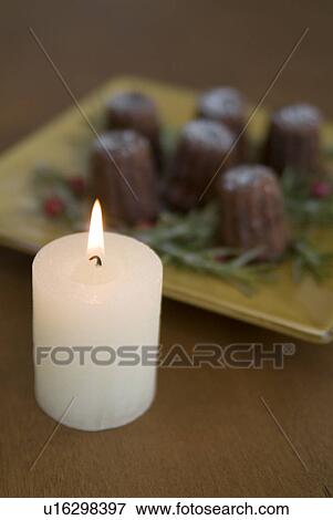 Stock Photo - Candle and canneles. Fotosearch