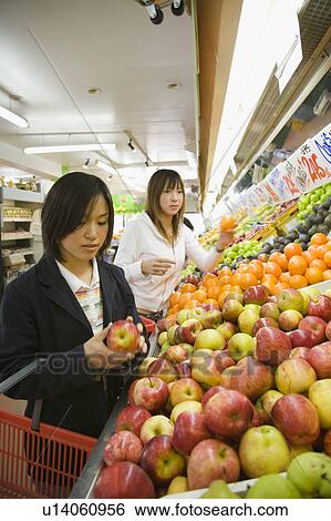 Two young women shopping in supermarket View Large Photo Image Stock Photograph - Two young women shopping in supermarket. Fotosearch