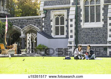 Stock Photo - Two young women sitting on lawn. Fotosearch
