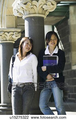 Stock Image - Two young women standing on corridor. Fotosearch