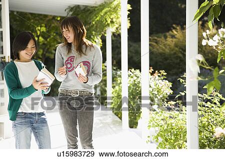 Stock Photo - Two young women talking on porch. Fotosearch