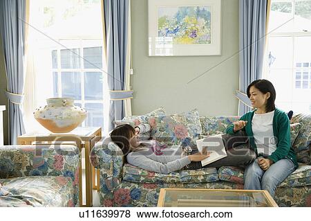 Two young women talking on sofa View Large Photo Image Stock Photo - Two young women talking on sofa. Fotosearch