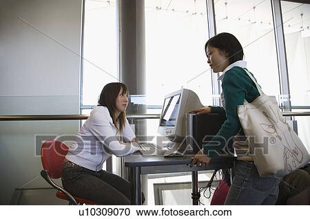 Two young women talking View Large Photo Image Stock Image - Two young women talking. Fotosearch