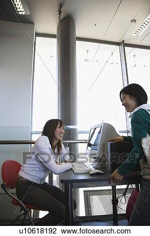Stock Image - Two young women talking. Fotosearch