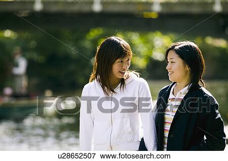 Two young women talking View Large Photo Image Stock Photo - Two young women talking. Fotosearch