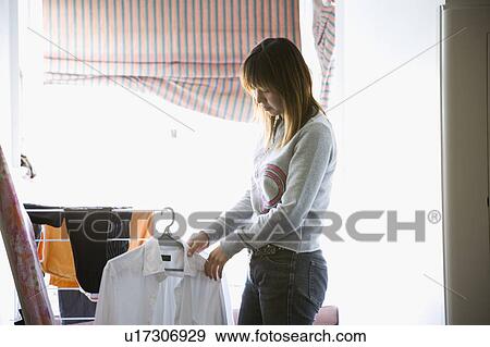 Young woman hanging clothes View Large Photo Image Stock Photo - Young woman hanging clothes. Fotosearch