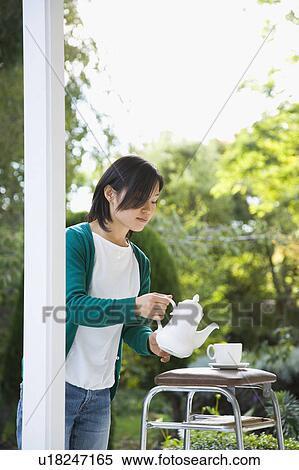 Young woman pouring tea View Large Photo Image Stock Photography - Young woman pouring tea. Fotosearch