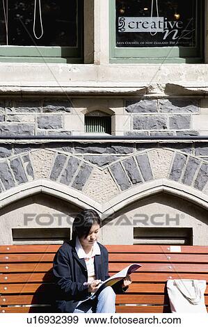 Young woman reading a book outside View Large Photo Image Stock Photo - Young woman reading a book outside. Fotosearch