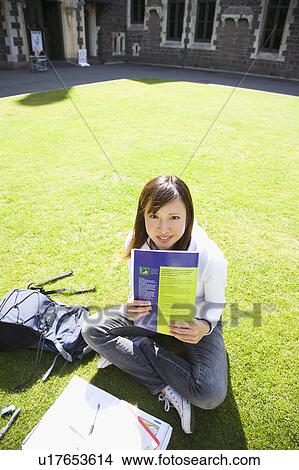 Picture - Young woman sitting on lawn. Fotosearch