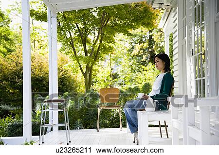 Young woman sitting on porch View Large Photo Image Stock Image - Young woman sitting on porch. Fotosearch