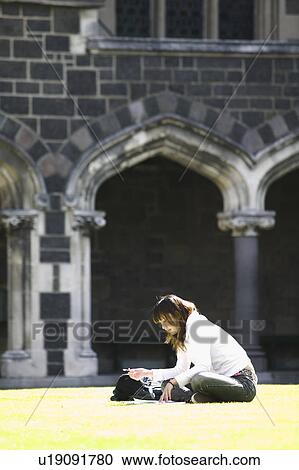 Young woman studying on lawn View Large Photo Image Stock Image - Young woman studying on lawn. Fotosearch