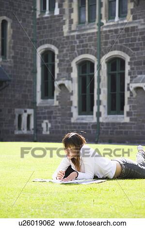 Young woman studying on lawn View Large Photo Image Stock Image - Young woman studying on lawn. Fotosearch