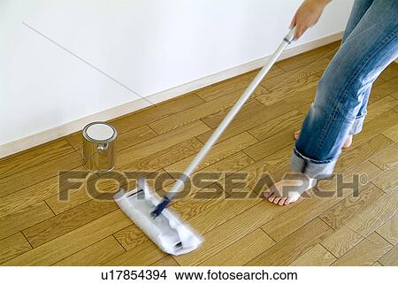 Picture - A woman cleaning floor with mop, blurred motion. Fotosearch