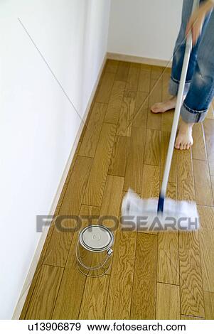 Stock Photo - A woman cleaning floor with mop, blurred motion. Fotosearch
