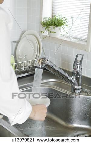 A woman washing dishes in kitchen View Large Photo Image Stock Image - A woman washing dishes in kitchen. Fotosearch