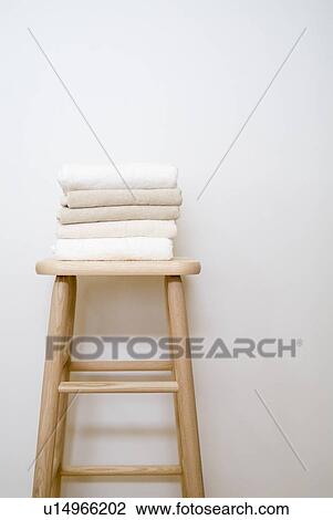Stock Image - Folded towels on stool. Fotosearch